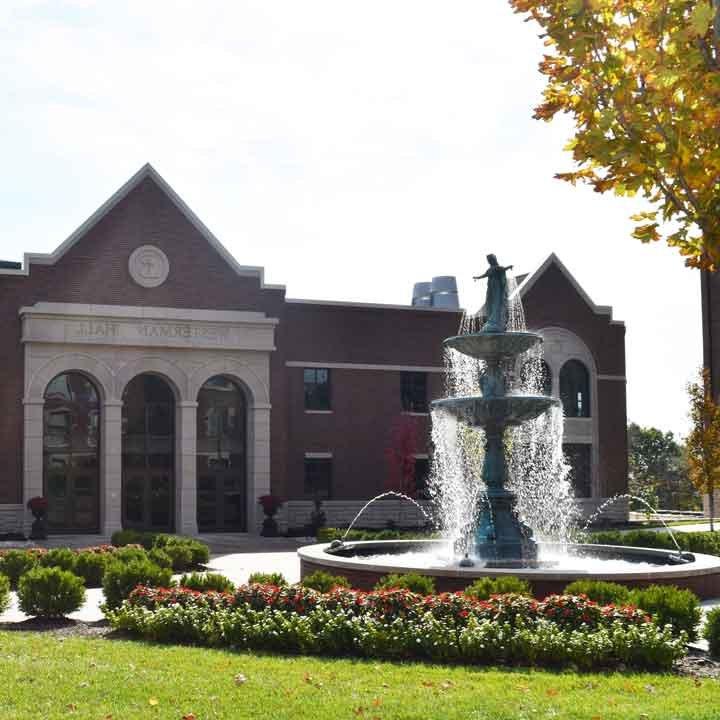 我们的圣母喷泉被鲜花包围，背景是费雷尔学术中心